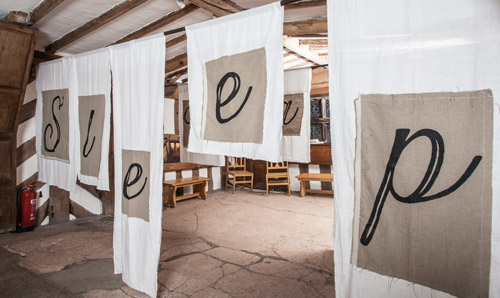 The word 'sleep' stitched onto hanging sheets